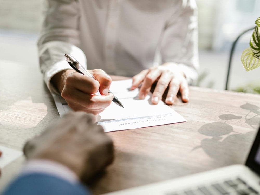 personne qui signe un contrat pour illustrer la signature de contrat d'assurance pour des garde-meubles à Tourcoing