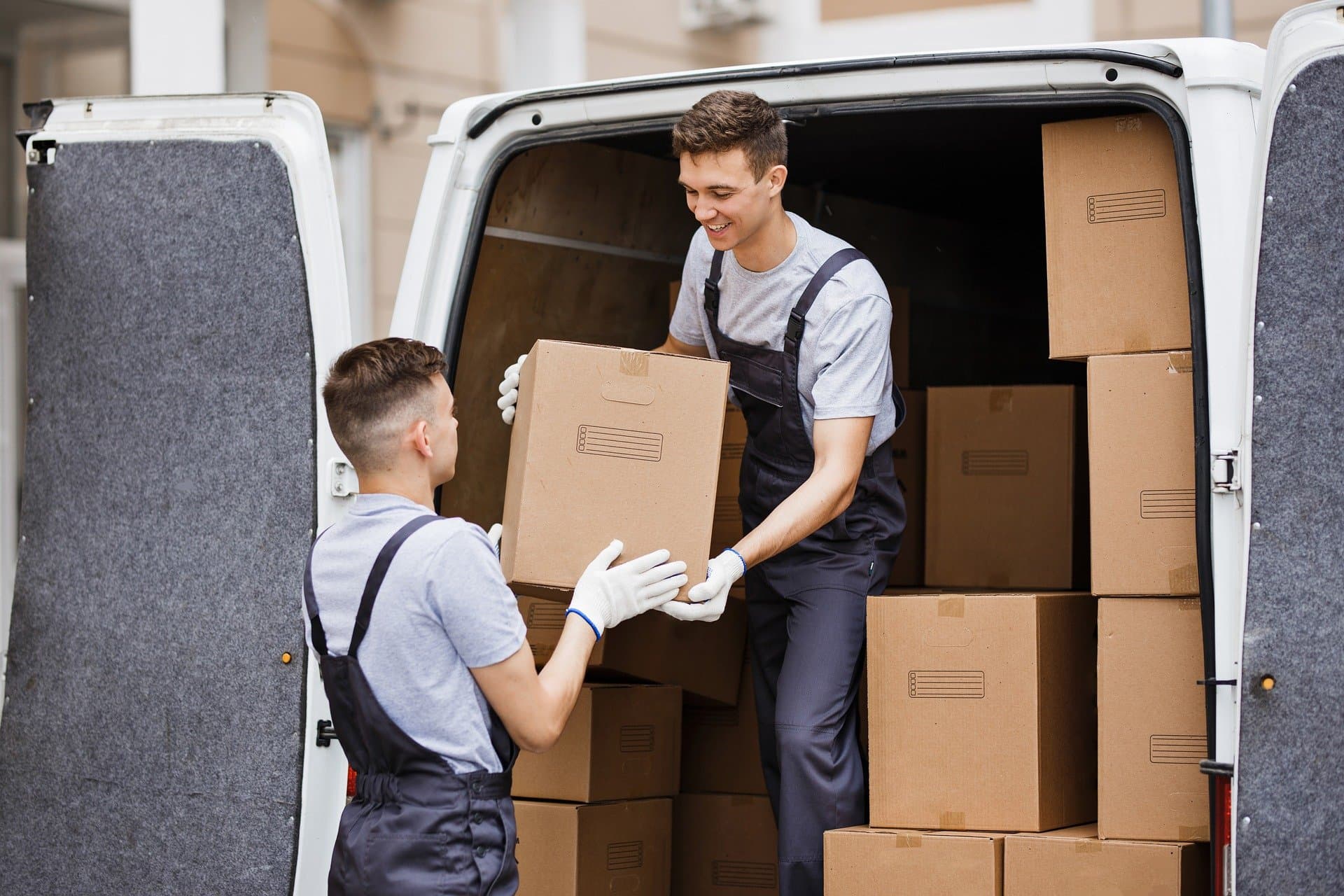 livraison carton, livreur qui se transmettent un carton pour un livraison